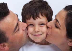 Loving family with a kid - parents kissing a little boy